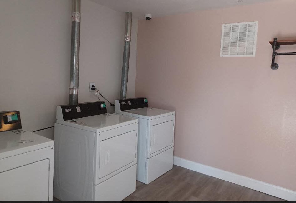 two washing machines in a room with pink walls